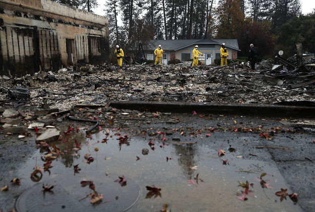  Search and rescue crews dig through the burnt remains of a business as they search for human remains. PHOTO: AFP