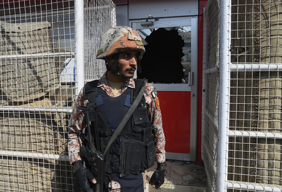 A Pakistani ranger stands in front of a damaged gate at the Chinese consulate after an attack in Karachi on November 23, 2018. PHOTO: AFP