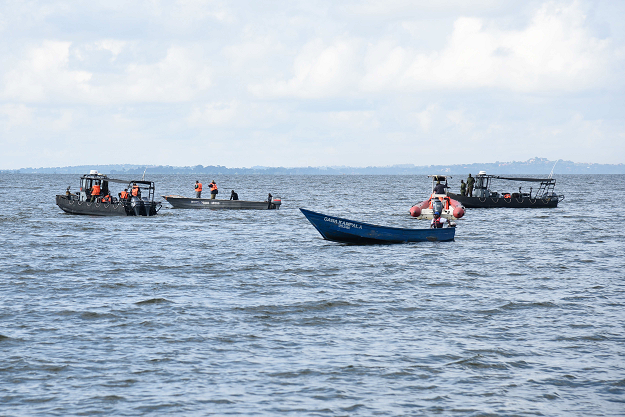  Local fishermen and Ugandan Navy personnel search passengers of capsized cruise boat on lake Victoria at Mutima village. PHOTO: AFP