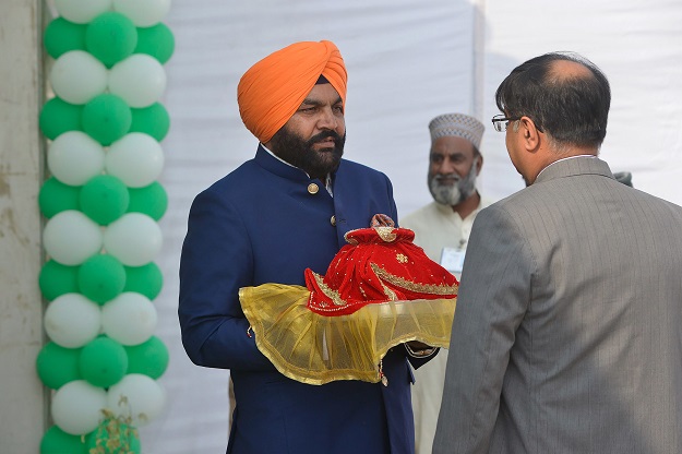 Indian Member of Parliament Gurjeet Singh Aujla (C) holds a pot containing water from the Sikh Golden Temple in Amritsar as he takes part in a groundbreaking ceremony for the Kartarpur Corridor in Pakistan's Kartarpur on November 28, 2018. - Pakistan Prime Minister Imran Khan will attend the groundbreaking ceremony of the religious corridor between India and Pakistan on November 28. PHOTO: AFP