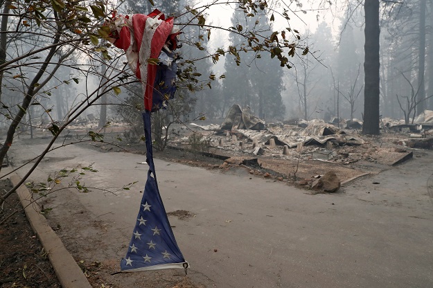 A tattered American flag hangs near homes destroyed by the Camp Fire in Paradise PHOTO: REUTERS