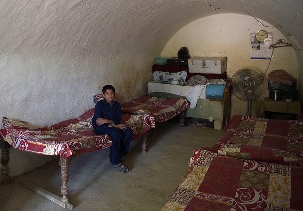 A young Pakistani villager sits in a cave room PHOTO: AFP