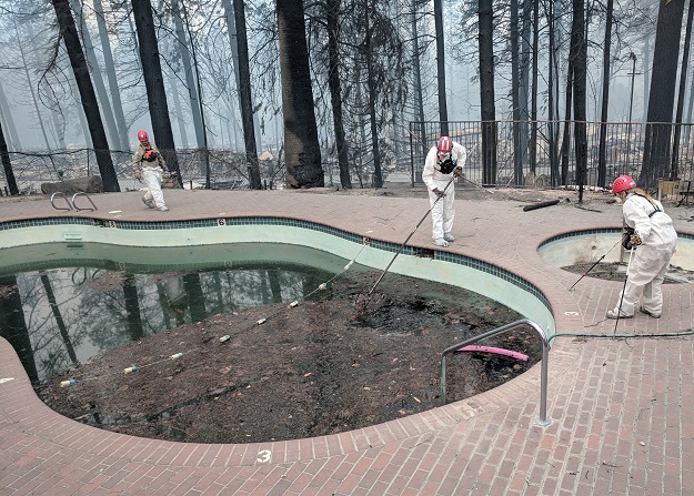 Forensic investigators search a community swimming pool for victims of the Camp Fire in Paradise. PHOTO: REUTERS