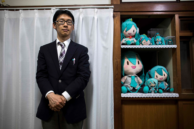 In this photograph taken on November 10, 2018 Japanese Akihiko Kondo poses next to the dolls of Japanese virtual reality singer Hatsune Miku, at his apartment in Tokyo, a week after marrying her. PHOTO: AFP
