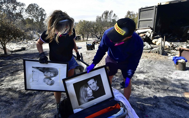 3.Katherine Marinara and her son Luca find what they came back to look for, old family photographs, at their burnt down house resulting from the Woolsey Fire on Busch Drive in Malibu PHOTO: AFP