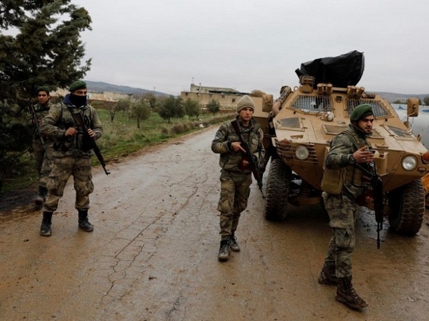 Members of Turkey-backed Free Syrian Army police forces secure the road as they escort a convoy near Azaz, Syria January 26, 2018. PHOTO: REUTERS