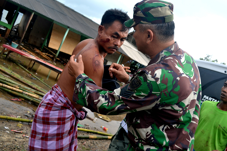 A soldier examines as he takes care of a local resident who was injured following a tsunami which hit at Tanjung Lesung district in Pandeglang, Banten province, Indonesia, December 23, 2018. PHOTO: REUTERS