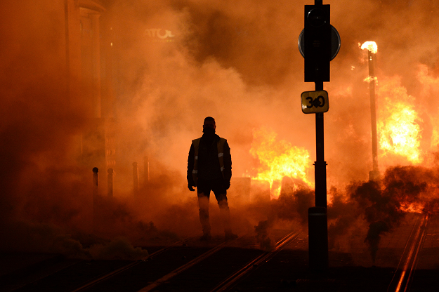 A protestor stands near a fire. PHOTO: AFP