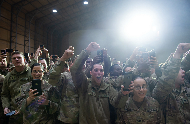 Members of the US military cheer as US President Donald Trump arrives to speak during an unannounced trip to Al Asad Air Base in Iraq. PHOTO: AFP