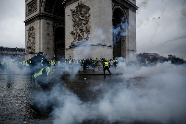 Demonstrators clash with riot police at the Arc de Triomphe during a protest of Yellow vests (Gilets jaunes) against rising oil prices and living costs, on December 1, 2018 in Paris. PHOTO:AFP