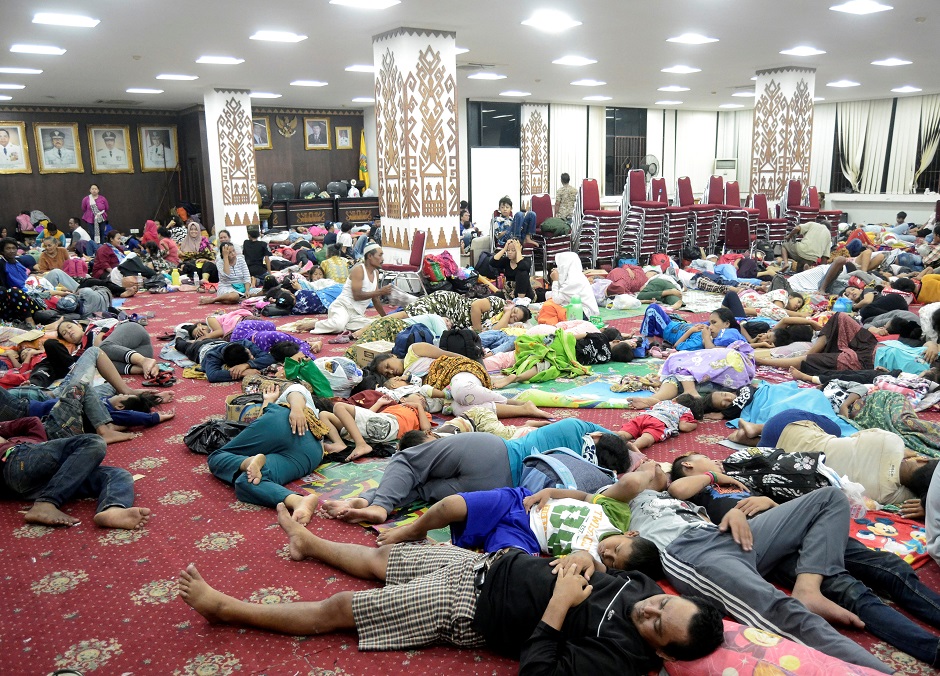 Residents, who lived at coast of Bandar Lampung, rest at government building after they evacuated following a tsunami hit Sunda strait in Lampung, Indonesia. Photo: Reuters