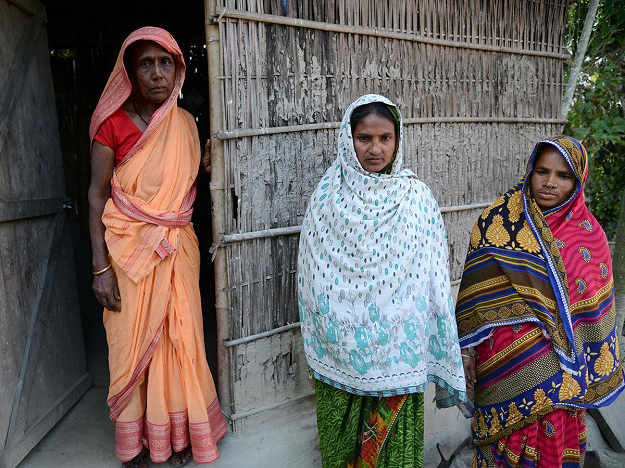 Baharjan Nesa (L), 88, stands with her daughters-in-law outside her home at Karaibil village in Kamrup district in India's northeastern Assam state. PHOTO: AFP