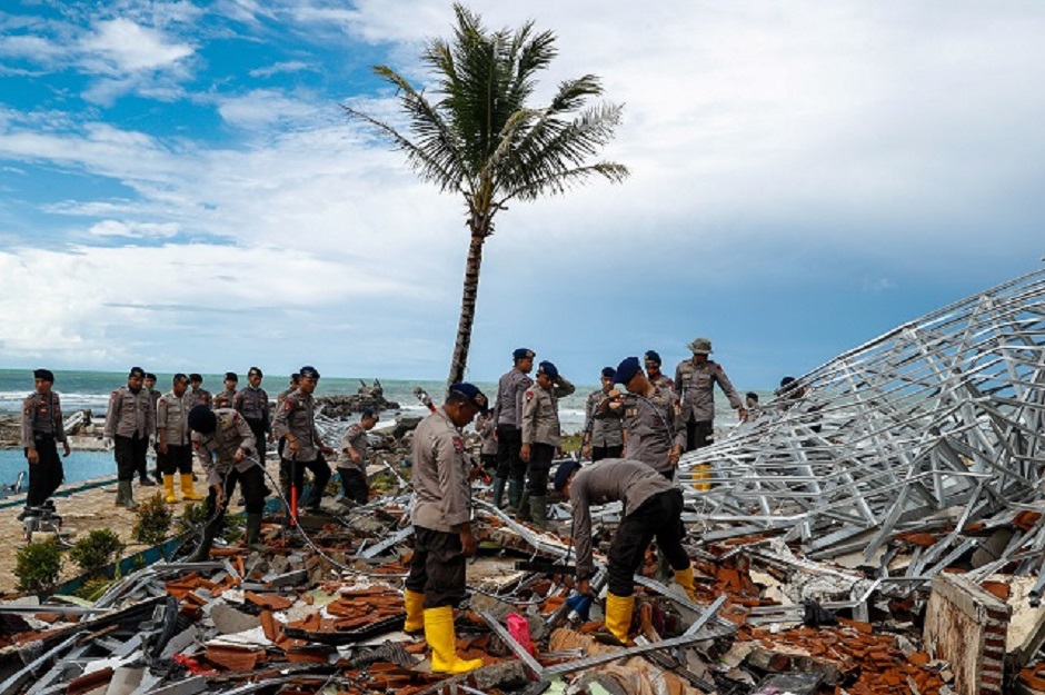 Police officers search for victims among rubble of a destroyed beach front hotel, which was hit by a tsunami in Indonesia. Photo: Reuters
