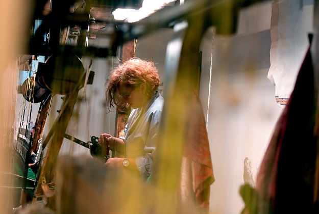This picture taken on October 29, 2018 shows a woman at work in the laboratory of the ancient silk factory of Antico setificio Fiorentino in Florence. PHOTO:AFP