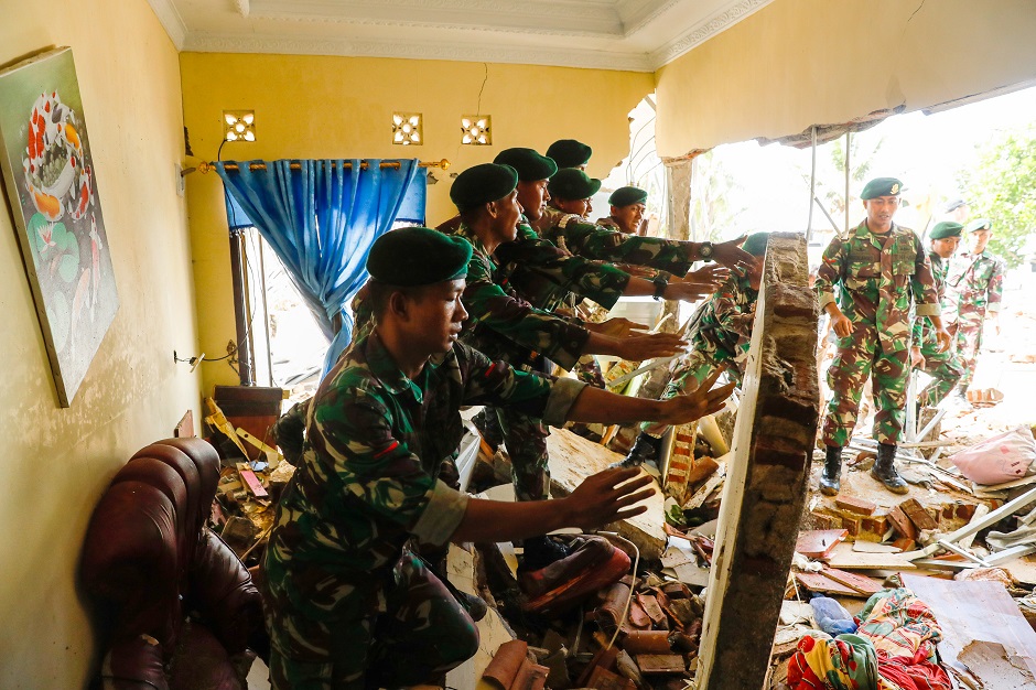 Soldiers search for bodies under a collapsed wall in a beach front hotel, which was hit by a tsunami in Pandeglang, Banten province, Indonesia. Photo: Reuters