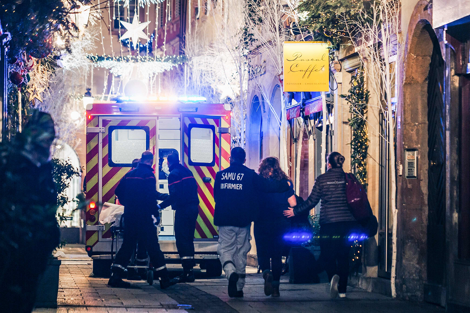 Emergency workers escort a woman after a shooting near the Christmas market in Strasbourg, eastern France, on December 11, 2018. PHOTO: AFP