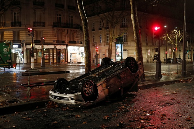 A vandalised car and bank front are seen the morning after clashes with protesters wearing yellow vests PHOTO: REUTERS