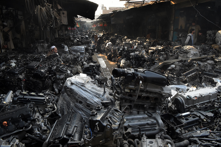 In this picture taken on January 16, 2019, Pakistani workers inspect used car engines displayed at a second hand vehicle parts market in Peshawar. PHOTO: AFP