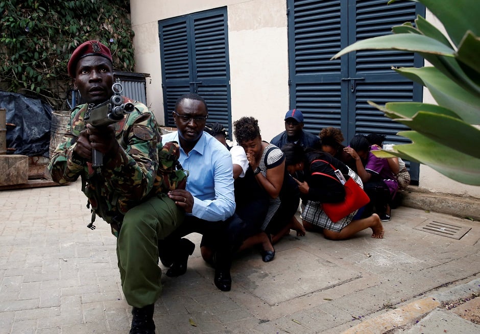 People are evacuated by a member of security forces at the scene where explosions and gunshots were heard at the Dusit hotel compound, in Nairobi, Kenya. PHOTO: REUTERS
