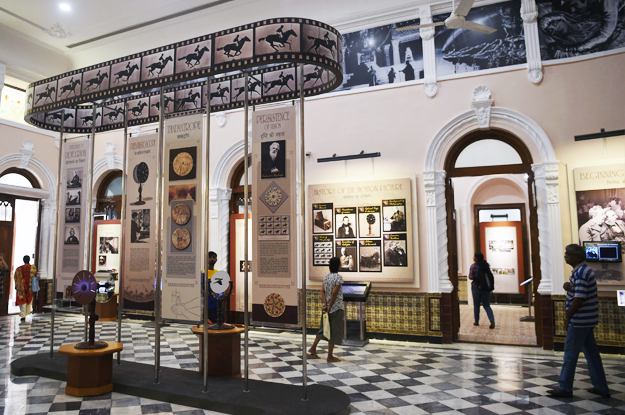 In this picture taken on January 22, 2019, visitors browse through exhibits at the National Museum of Indian Cinema (NMIC), the country's first museum showcasing the history of its film industry, in Mumbai. - From silent black-and-white films to colourful blockbusters bursting with song and dance, a new museum tracing the evolution of Indian cinema has opened in the home of Bollywood. Costing 1.4 billion rupees (19.6 million USD), India's first national film museum is spread across a stylish 19th-century bungalow and a modern five-storey glass structure in south Mumbai. (Photo by PUNIT PARANJPE / AFP) 