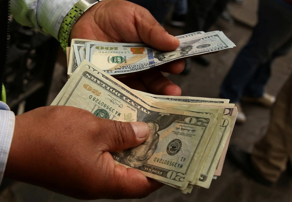 A money changer holds U.S. dollar bills at a street in downtown Lima, Peru, December 15, 2017. REUTERS/Mariana Bazo