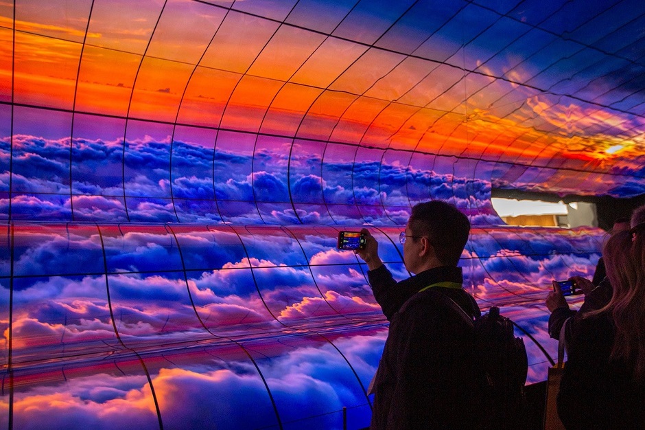 People take smartphone pictures of a large panel of curved LG OLED TVs at CES International in Las Vegas. PHOTO: AFP