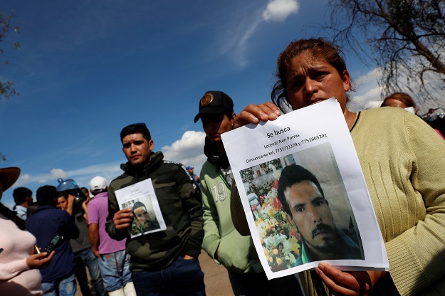 Residents hold pictures of their missing relative at the site where a fuel pipeline ruptured by suspected oil thieves exploded, in the municipality of Tlahuelilpan, Mexico January 19, 2019. PHOTO: REUTERS 