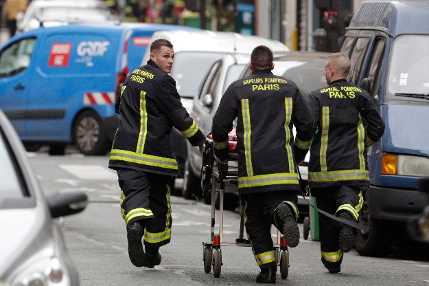 Firefighters run with a stretcher towards the scene of an explosion of a bakery on the corner of the streets Saint-Cecile and Rue de Trevise in central Paris. PHOTO: AFP