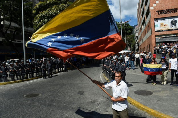 An opposition demostrator waves a Venezuelan national flag during a protest against the government of President Nicolas Maduro in Caracas. PHOTO: AFP
