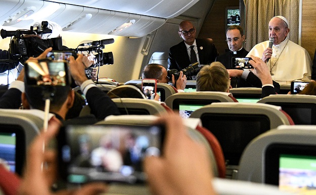 Pope Francis speaks to reporters aboard a plane on his way to Abu Dhabi. PHOTO: AFP