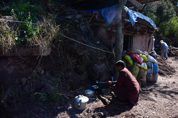  Kashmiri resident prepares food outside a bunker adjacent to his house in Dhanna village. PHOTO: AFP