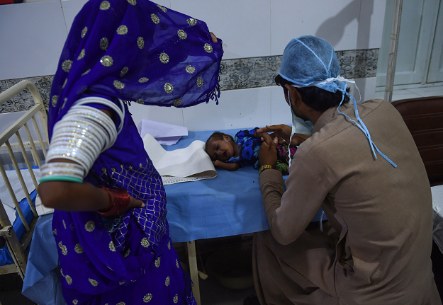 A medic treats a baby girl at Mithi Civil Hospital . PHOTO: AFP