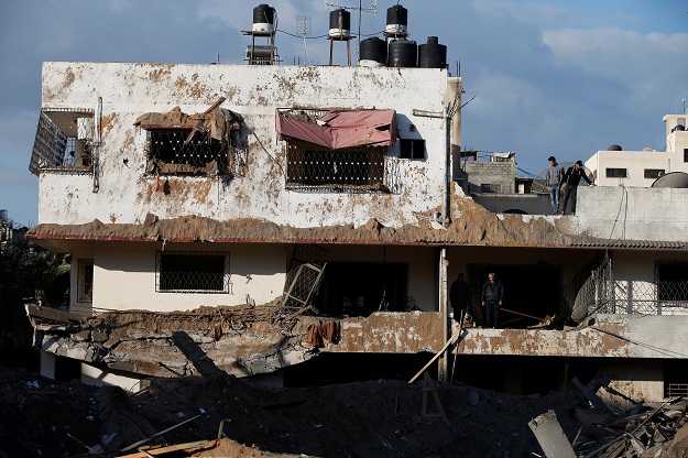 Palestinians inspect their house that was damaged in a nearby Israeli air strike in Gaza City March 26, 2019.  PHOTO: Reuters