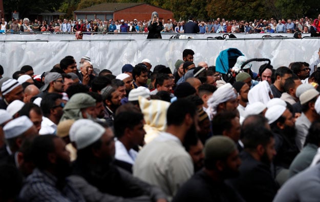  A woman takes photo with her mobile phone of people attend the Friday prayers at Hagley Park outside Al-Noor mosque in Christchurch, New Zealand March 22, 2019. PHOTO: REUTERS