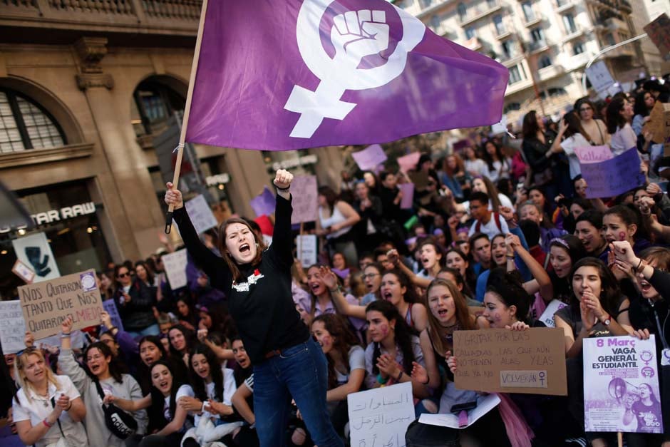 A woman waves a feminist flag as student protesters shout slogans during a demonstration marking International Women's Day in Barcelona. PHOTO: AFP