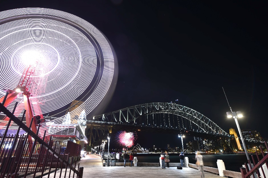 The Sydney Harbour Bridge, the Opera House and the ferris wheel are seen before being plunged into darkness from Sydney's Luna Park for the Earth Hour environmental campaign on March 30, 2019. PHOTO: AFP