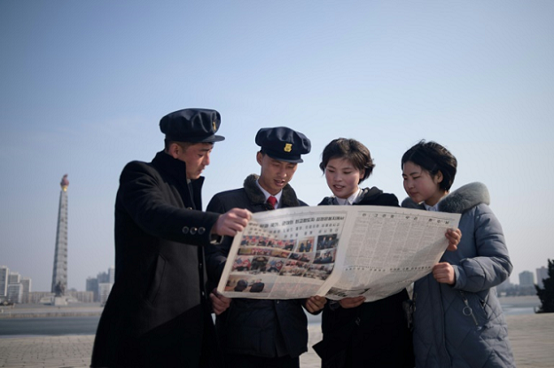 North Korean students read the newspaper coverage of Kim Jong Un's summit with US President Donald Trump. PHOTO: AFP