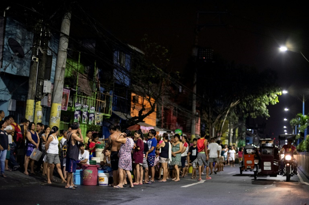 Bucket-bearing families wait hours to fill up from tanker trucks and some hospitals to turn away less urgent cases in Manila. PHOTO: AFP