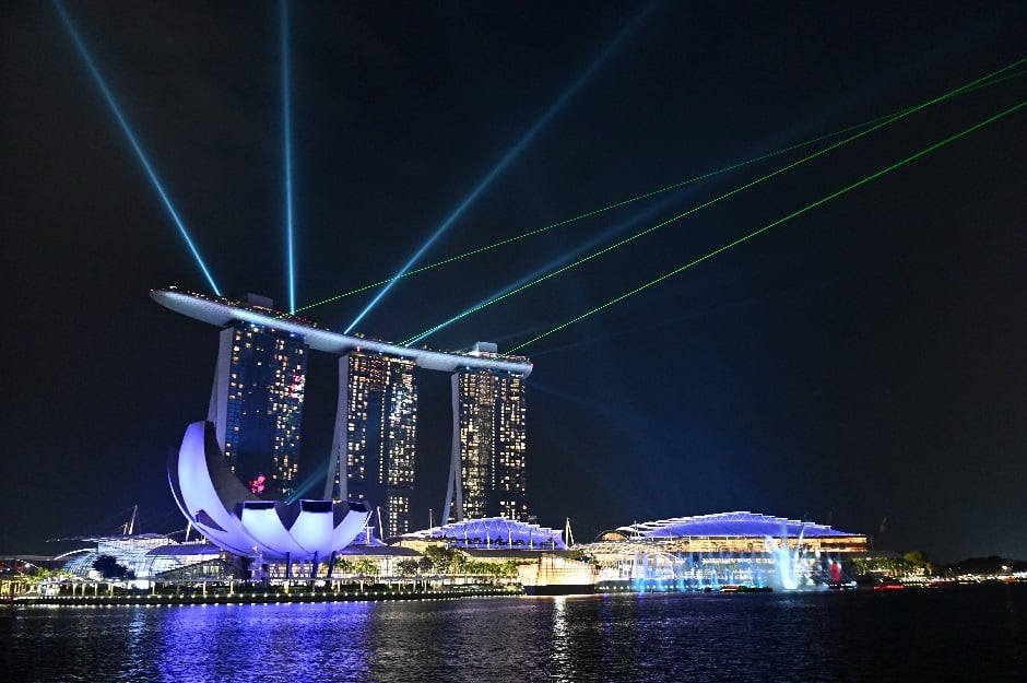A general view of the Marina Bay Sands hotel and resort are seen lit shortly before the lights were turned off for the Earth Hour environmental campaign in Singapore on March 30, 2019. PHOTO: AFP