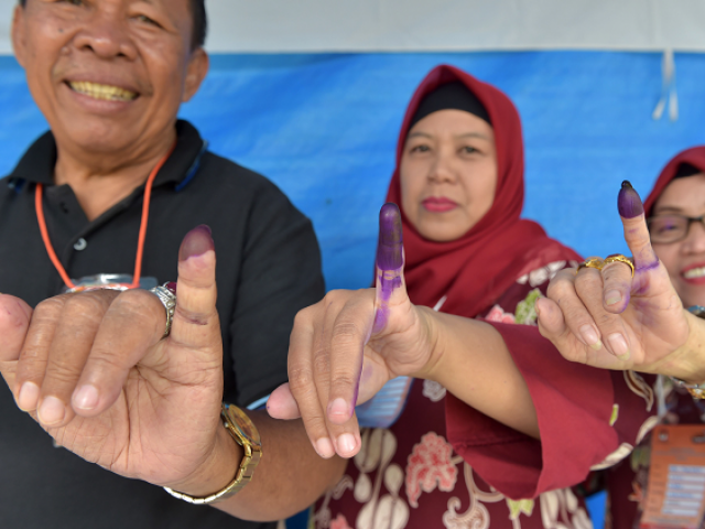 Indonesian people show their inked fingers after casting their ballots during regional elections in Tangerang. PHOTO: AFP