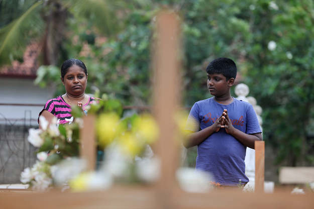  People react during mass burials near St. Sebastian church in Negombo. PHOTO: REUTERS