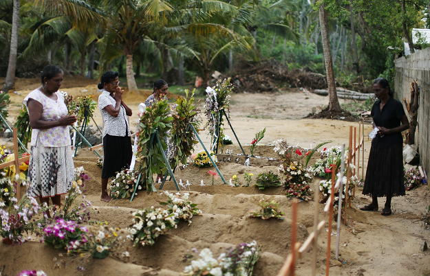 People react during mass burials near St. Sebastian church in Negombo. PHOTO: REUTERS