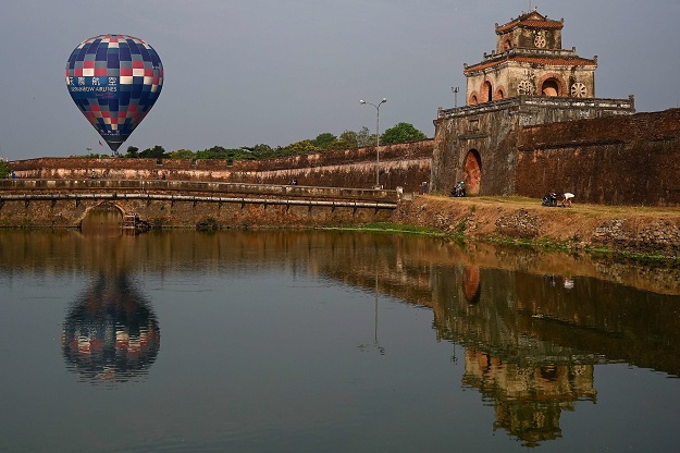 A hot air balloon flies over the former capital's stone citadel during a hot air balloon festival in the central Vietnamese city of Hue on April 28, 2019. PHOTO: AFP