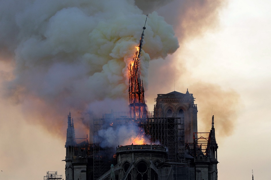 The steeple of the landmark Notre-Dame Cathedral collapses as the cathedral is engulfed in flames in central Paris. PHOTO: AFP