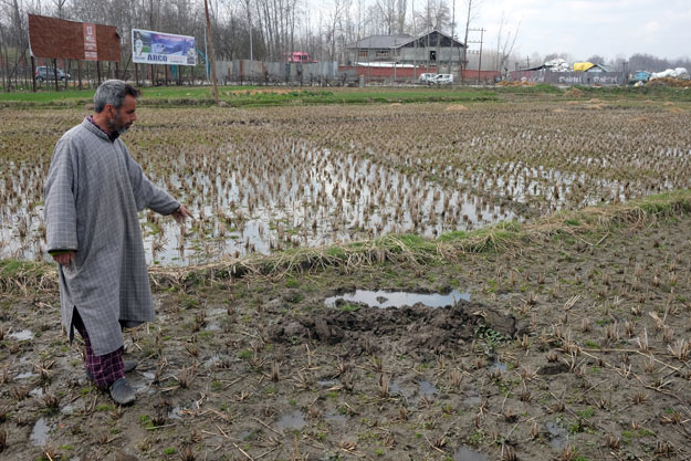 Shafqat Ahmad Bhat points to where he says he was forced to bury an unexploded rocket used by the Indian army in Pinglan village in occupied Kashmir's Pulwama district March 21, 2019. PHOTO: REUTERS