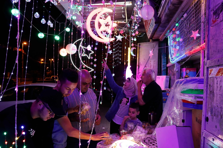 Palestinians check a shop selling Ramadan lights in the old city of Jerusalem on May 4, 2019, as Muslims around the world prepare for the announcement of the fasting month of Ramadan which is expected to start on May 5 or 6 depending on the crescent moon. PHOTO: AFP
