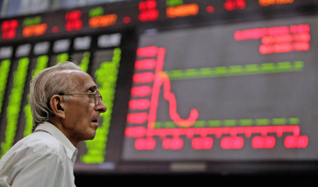 A man monitors an electronic board displaying stock prices at the Karachi Stock Exchange August 5, 2011. Pakistani stocks provisionally ended 3.78 percent lower on Friday as foreign investors offloaded their holdings amid a global sell-off, while local investors remained cautious, dealers said. REUTERS/Akhtar Soomro/File Photo
