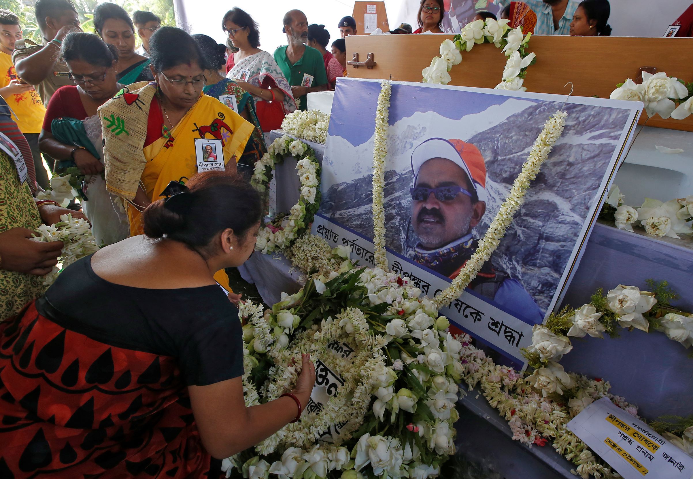 people pay homage in front of a portrait of dipankar ghosh a 52 year old indian photographer who scaled the world 039 s fifth highest peak the snow capped mount makalu before his funeral in howrah district in the eastern state of west bengal india may 29 2019 reuters