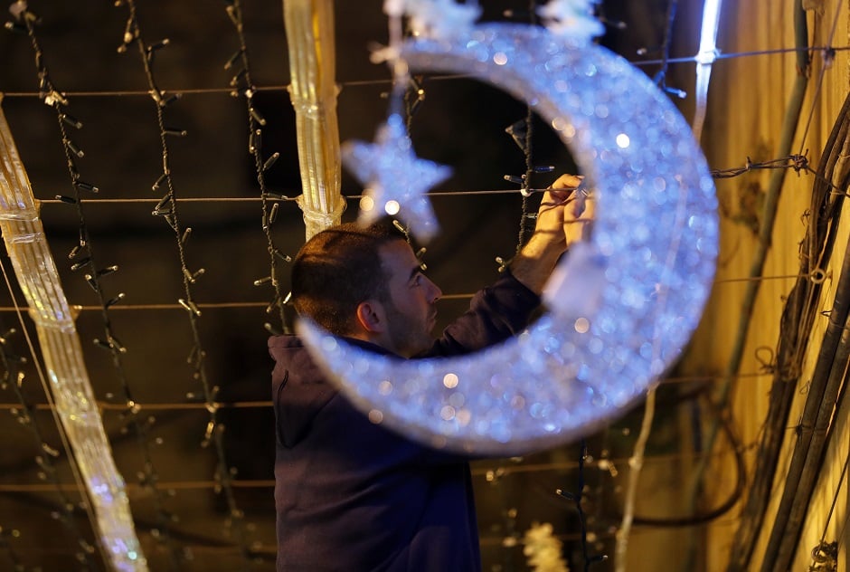 2.A Palestinian man decorates with lights near the entrance of the al-Aqsa mosque compound, in the old city of Jerusalem on May 4, 2019, as Muslims around the world prepare for the announcement of the fasting month of Ramadan. Ramadan is expected to start on May 5 or 6 depending on the crescent moon. PHOTO: AFP
