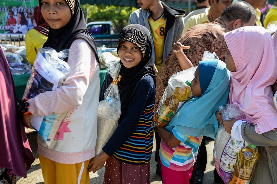 5.Thai Muslim girls carry bags of rice and food donated by the local government during a ceremony ahead of the Islamic holy month of Ramadan in the southern Thai province of Narathiwat. PHOTO: AFP